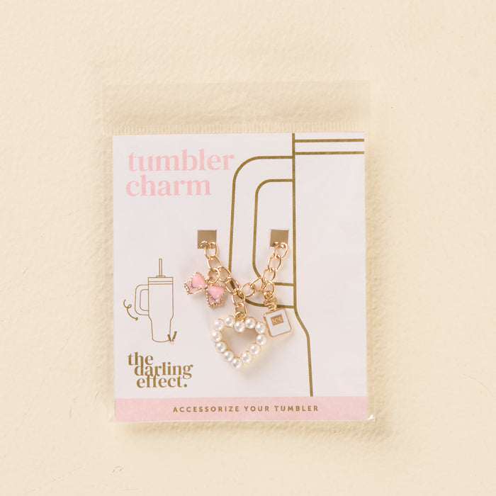 Add sparkle to your tumbler with the-darling-effect’s Glamour Tumbler Charm—featuring a gold chain, pink gem, pink bow, and white beaded heart! Packaged with "tumbler charm" and a cup graphic for stylish flair.