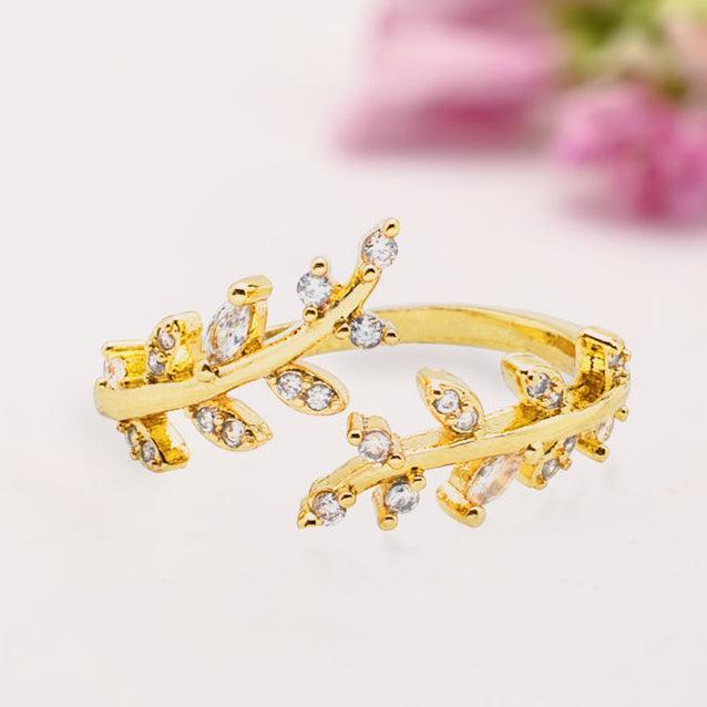 Gold ring with leaf design on a light background