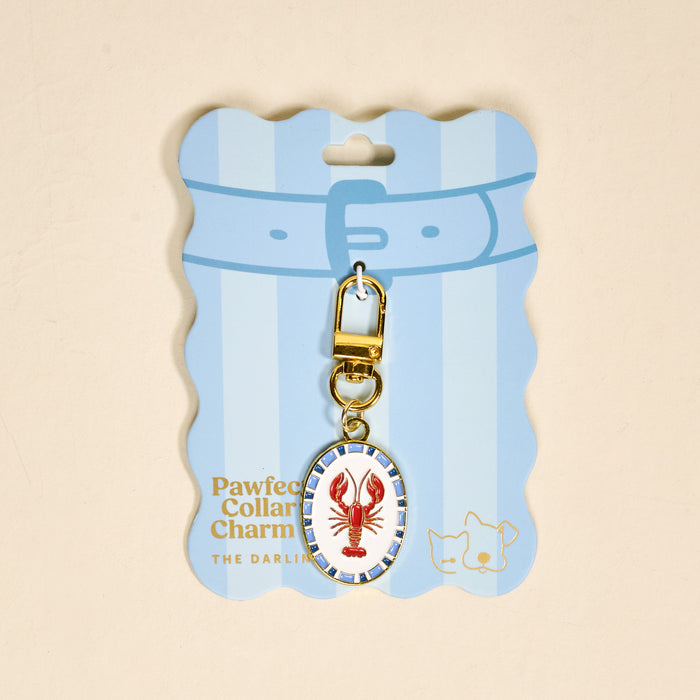 The Darling Effect Lobster Pawfect Collar Charm, presented on a blue striped card reading "Pawfect Collar Charm THE DARLIN," is a stylish accessory for your pet's collar.