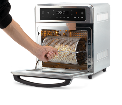 Removing the rotating mesh fry basket using the handle tool from the open Cosori Air Fryer Oven