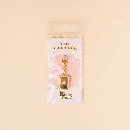 The-darling-effect’s A Jewelry Charm Initial Letter Gold features a gold-plated letter and clasp, attached to an “OH SO charming and the darling effect” card, all in a clear pouch—a perfect personalized jewelry piece.