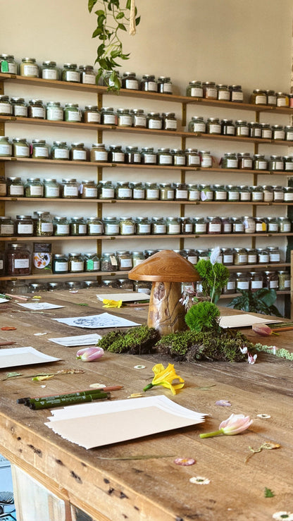 Shelving unit with various jars and a wooden table with decorative items.
