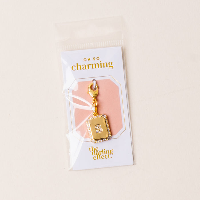 The B Jewelry Charm Initial Letter Gold from the-darling-effect is attached to an "Oh So Charming" card and comes sealed in a clear plastic bag, making it a perfect personalized gift.