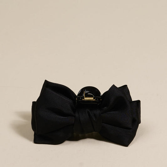 The Darling Effect Black Mini Satin Bow Claw Clip features a chic satin bow and gold clasp, adding elegance to any hairstyle.