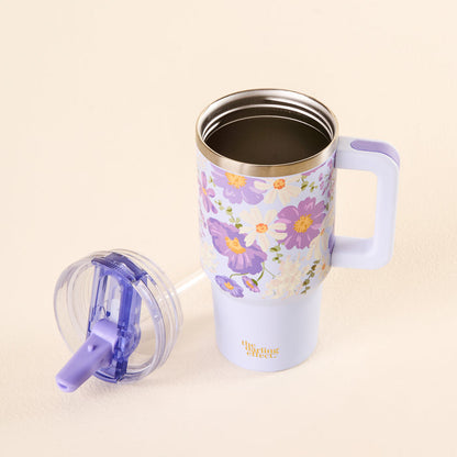 The-darling-effect’s Bouquet Beauty Purple 20 oz Lifestyle Flip Straw Tumbler with a floral design and handle sits on a light surface. Its clear, leak-resistant lid is beside it, and "Uplifting Effect" is written in gold on the mug.