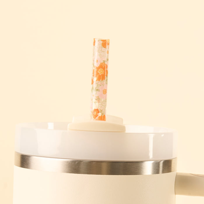 The the-darling-effect Bouquet Beauty Sage 40 oz Tumbler Straw Set features a BPA-free reusable straw with an orange floral pattern, standing upright in the lid of a white insulated tumbler against a cream background.