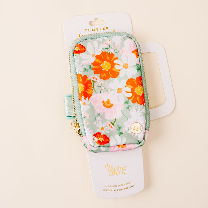 The Bouquet Beauty Sage Tumbler Fanny Pack by the-darling-effect features pastel red, orange, and white florals. This hands-free, water-resistant pouch keeps essentials secure on the go. Packaged in white and shown on a cream background.
