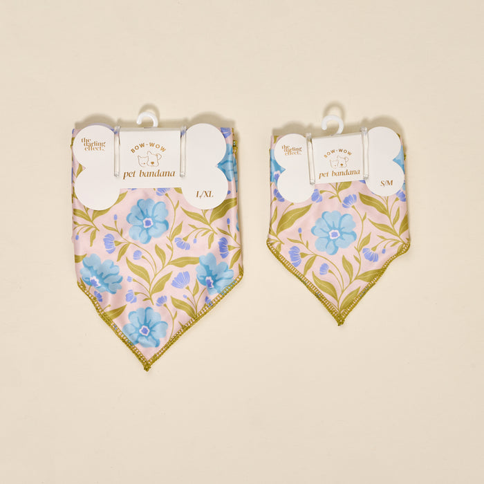 Two aqua floral cotton dog bandanas by The Darling Effect, labeled L/XL and S/M, hang side by side. Each displays “Bow-Wow Pet Bandana-Poppin' Petals Aqua” tags and the brand name.