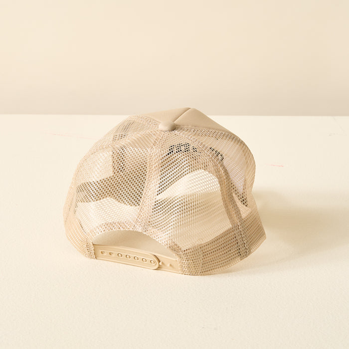 The Darling Effect Boy Mom Trucker Hat is shown from the back, featuring a beige mesh design with an adjustable snapback closure, classic trucker style, and displayed on a light surface against an off-white background.