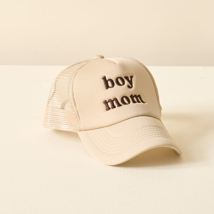 The Darling Effect’s Boy Mom Trucker Hat features beige fabric with brown embroidered “boy mom” lettering.