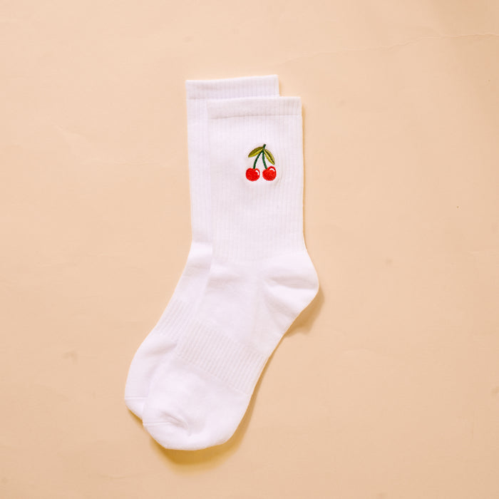 The Darling Effect’s Cherries Embroidered Crew Socks feature a white base with red cherry and green stem embroidery—colorful, playful socks for women.