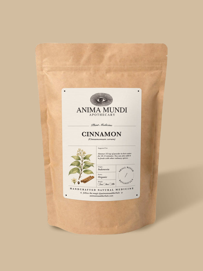 A stand-up kraft paper pouch of Anima Mundi Apothecary Cinnamon, featuring a white label with botanical illustrations, set against a solid beige background.