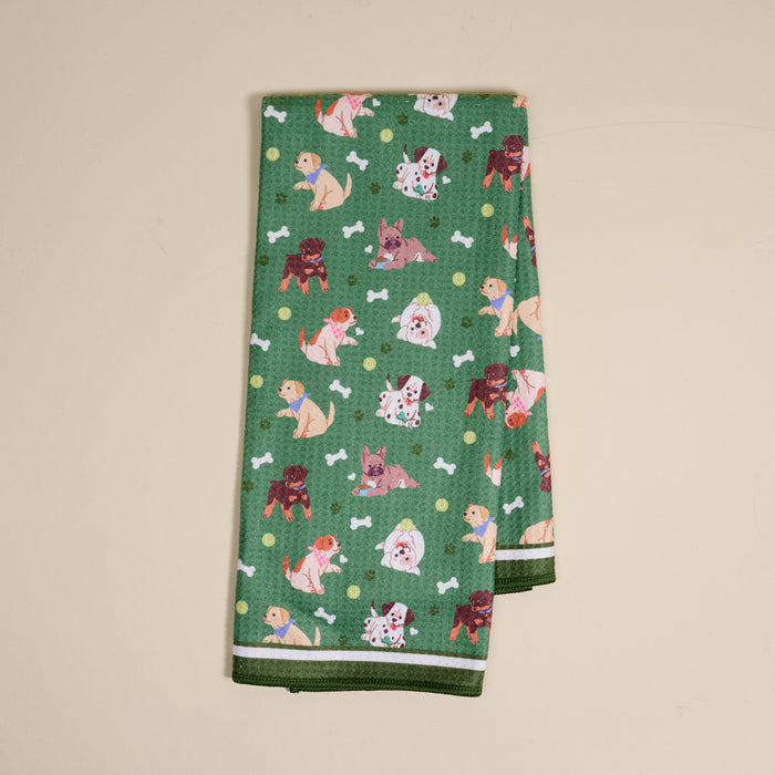 The Darling Effect's Dog Days Waffle Tea Towel features a green cartoon dog, white bone, and yellow dot pattern—absorbent and ideal for everyday kitchen use.