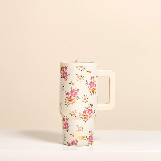 The-darling-effect Endless Daydream Cream 20 oz Lifestyle Flip Straw Tumbler features a pink floral pattern, insulated stainless steel build, and cream handle, shown on a cream background.