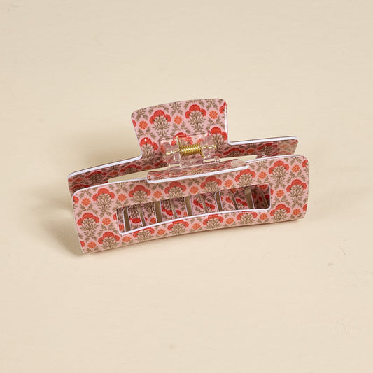 The Darling Effect's Everbloom Dusty Rose Claw Clip features a pink and red floral print in a rectangular shape, showcased upright against a light beige background.