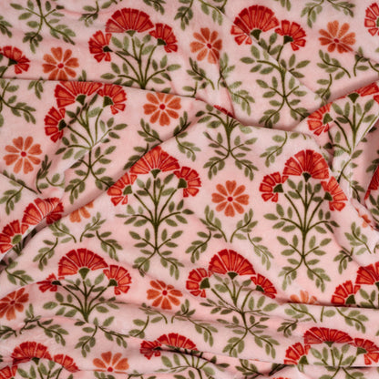 The Darling Effect’s Everbloom Dusty Rose Snuggle Up Plush Blanket features pink fuzzy fabric with red and orange floral patterns and green leaves—perfect to brighten any room with cozy softness.