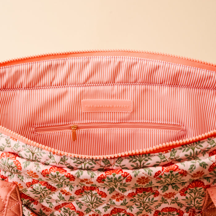 The Everbloom Dusty Rose The Everyday Quilted Tote Bag by The Darling Effect features an open floral quilted design, pink and white striped lining, inner zip pocket, and a branded label—perfect for daily use.