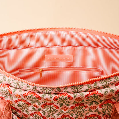 The Everbloom Dusty Rose The Everyday Quilted Tote Bag by The Darling Effect features an open floral quilted design, pink and white striped lining, inner zip pocket, and a branded label—perfect for daily use.