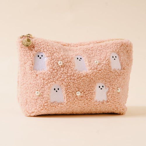 The Darling Effect's Ghosts & Pearls Teddy Pouch is a fluffy, light pink sherpa pouch with white embroidered ghosts and pearl-like beads on the front, displayed on a plain beige background.