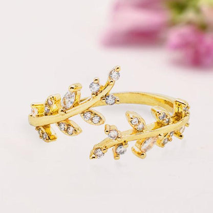 Gold ring with leaf design on a light background