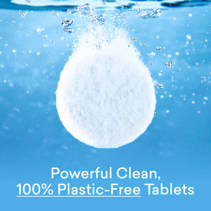 A white tablet from the Hand Soap Starter 2-Pack dissolves in water, releasing bubbles against a blue background. Text below reads: Powerful Clean, 100% Plastic-Free Hand Soap Tablets.