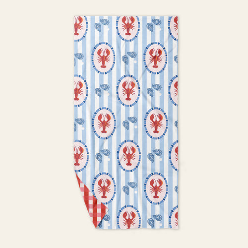 The Darling Effect Harbor House XL Quick-Dry Beach Towel features blue and white stripes, lobster designs with oyster shells, a red and white gingham underside, and sand-resistant microfiber—perfect for your next stylish seaside adventure.