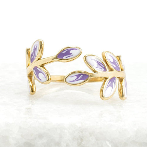 Gold ring with purple enamel leaves on a white background
