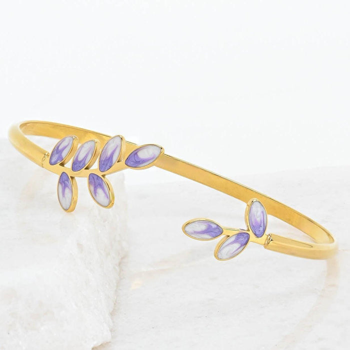 Gold bracelet with purple  enamel leaves on a white background