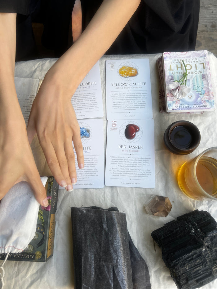 Hands interacting with various items including boxes and a cup on a white surface.