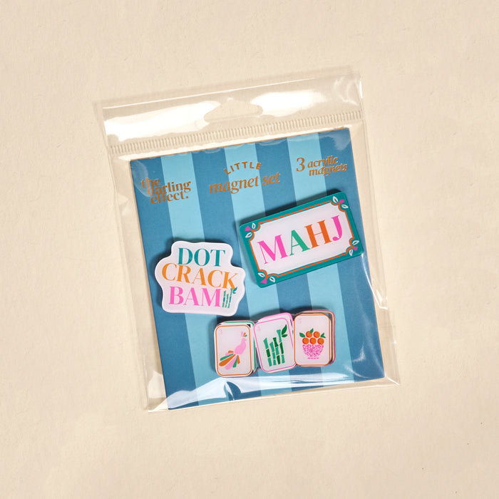 The Darling Effect Let's Play Mahjong Little Magnet Set includes 3 acrylic fridge magnets on a blue striped card, each featuring stylish mahjong tile designs with sayings like MAHJ and DOT CRACK BAM.