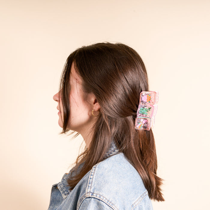 A young woman with brown hair and a denim jacket wears The Darling Effect’s Mahjong Tiles Shape Up Claw Clip—a playful, stylish accessory that adds a cute touch to her hairstyle.