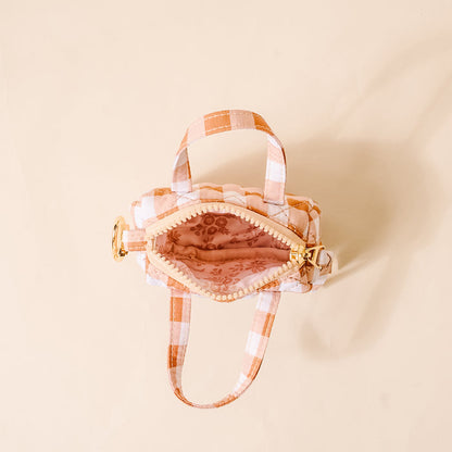 Small open duffle bag charm in orange-and-white gingham with gold clasp and keyring