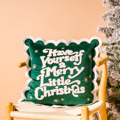 The Darling Effect Merry Little Christmas Scalloped Square Throw Pillow, featuring festive white lettering and scalloped edges, adds a cozy holiday touch to your space.