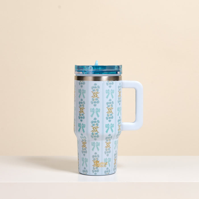 The Oh So Fancy Blue 20 oz Lifestyle Flip Straw Tumbler by the-darling-effect, featuring blue bows and yellow flowers, sits on a white surface. Its insulated stainless steel keeps drinks at the ideal temperature.