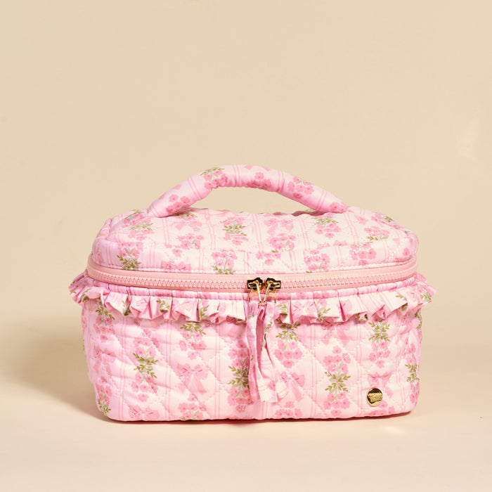 The Darling Effect's Oh So Fancy Pink Glam & Go Quilted Cosmetic Bag features a floral print, ruffles, and gold zipper with tassel—ideal for stylish travel makeup organization.