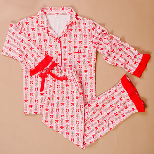 The Darling Effect's Oh So Merry Sweet Dreams Pajama Pants Set features white pajamas with red bows and floral prints, ultra-soft fabric, and red trim on the cuffs and waistband—perfect for cozy nights.