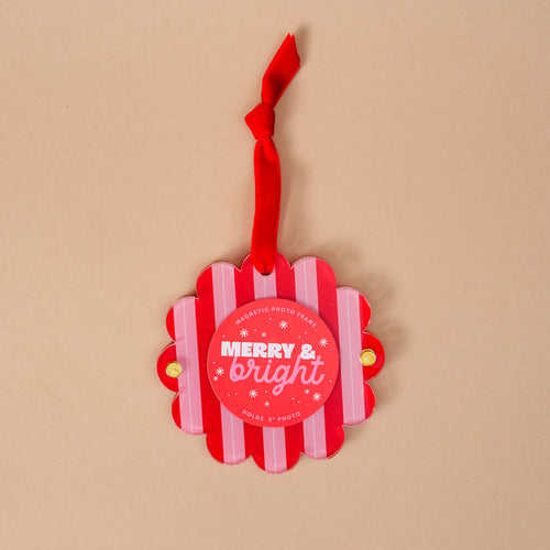 The Darling Effect's Peppermint Stripes Scalloped Round Picture Frame Ornament features red and white stripes, a red ribbon, "MERRY & bright" in white text, and snowflake accents—perfect for your holiday display!.