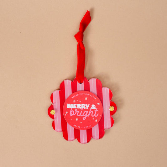 The Darling Effect's Peppermint Stripes Scalloped Round Picture Frame Ornament features red and white stripes, a red ribbon, "MERRY & bright" in white text, and snowflake accents—perfect for your holiday display!.