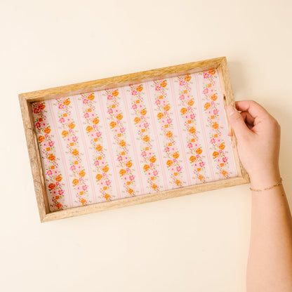 The Petal Parade Pink Rectangle Wood Enamel Tray by the-darling-effect features hand-painted pink and orange florals on a striped pink background—this handcrafted, food-safe tray is perfect for stylish serving.