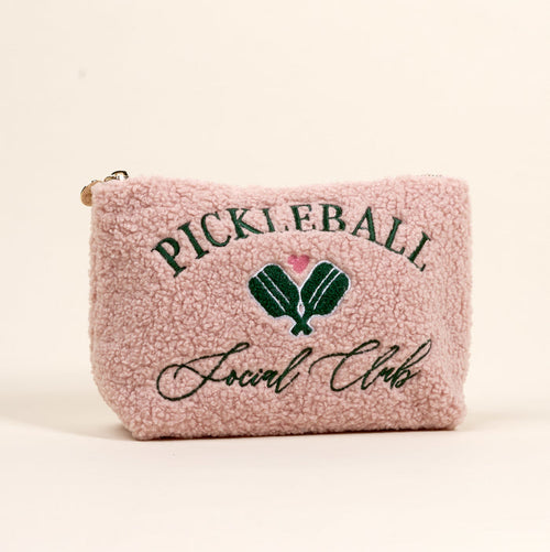 The Darling Effect’s Pickleball Social Club Teddy Pouch features pink sherpa fabric, green “PICKLEBALL Social Club” text, and embroidered green paddles with a pink heart—an adorable must-have accessory.