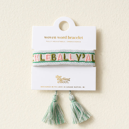 A woven bracelet with green and pink embroidered “Pickleball Yall” on a white and mint band, displayed on a card reading “The Darling Effect” with matching mint and white tassels below. Adjustable for a perfect fit.