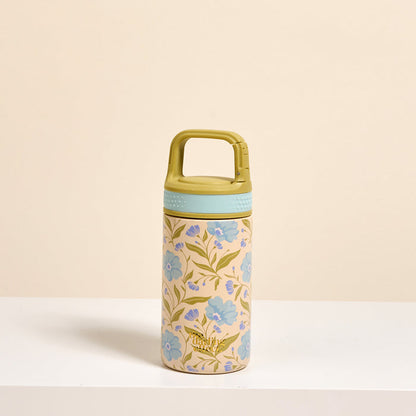 The Darling Effect’s Poppin' Petals Aqua 6 oz Lil' Bitty Bottle features a green handle lid and blue-gold floral design on beige—stylish hydration on the go, shown on a white surface with a light beige background.