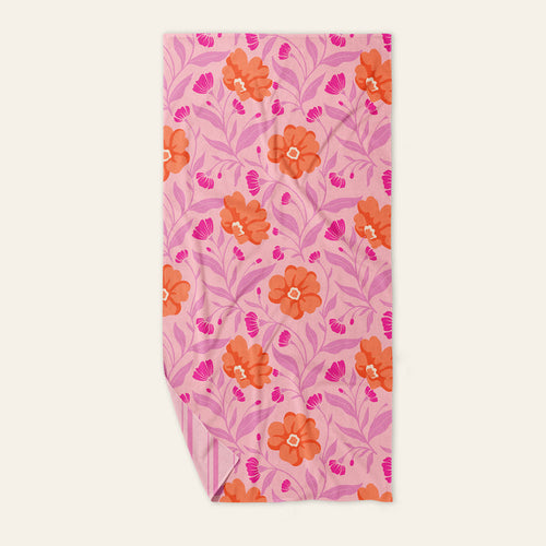 The Darling Effect Poppin' Petals Hot Pink XL Quick-Dry Beach Towel features an orange and pink floral pattern with leaf designs and a striped underside, combining vibrant style and fast-drying comfort for sunny beach days.