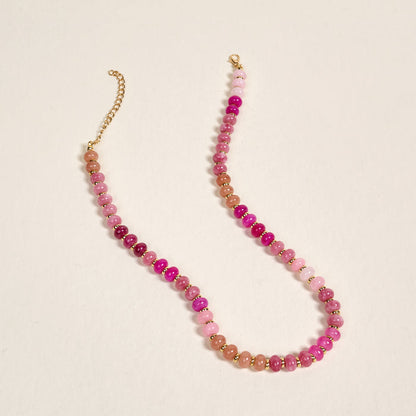 The Darling Effect's Pretty Pinks Stone Candy Necklace features pink and purple beads with an adjustable gold chain clasp, displayed on a simple light background.
