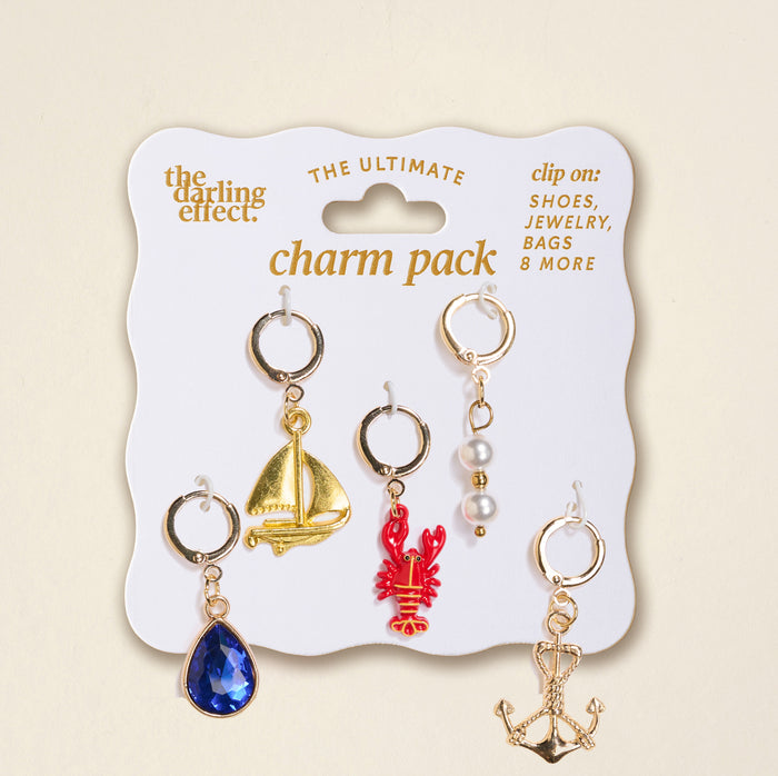 The Darling Effect's Sail Away The Ultimate Charm Pack features five gold and silver charms—a blue teardrop gem, sailboat, red lobster, pearls, and anchor—perfect for clip-on shoes, jewelry, bags or scrunchie charm sets.