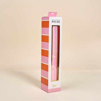 The Darling Effect Sicily Stripes Pink Style Station Desk Mat comes in striped pink packaging with a window cutout revealing the chic, non-slip mat inside—perfect for enhancing your workspace against any neutral background.