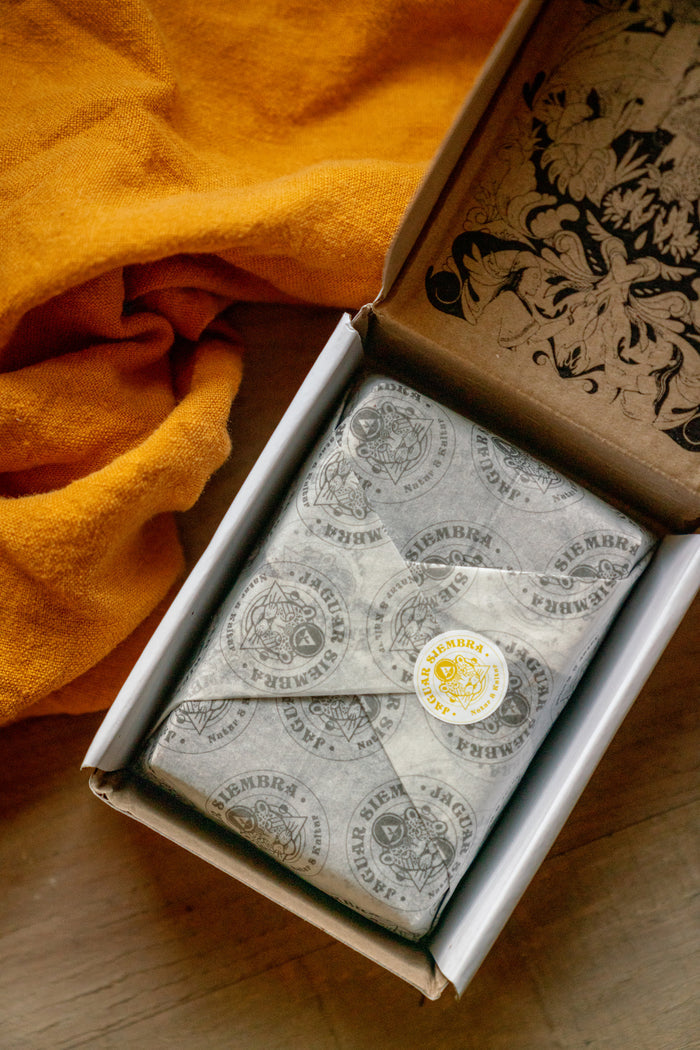 Box of tea bags with a decorative label on a wooden surface with an orange cloth.