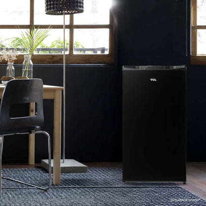 TCL 18 in. 3.1 Cu. Ft. Compact Single Door Mini Fridge in Black (TRM31S4AB) in a room with a dining table and chairs.