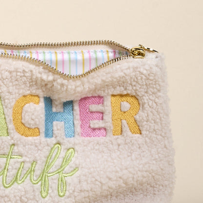 The Teacher Stuff Teddy Pouch by the-darling-effect is a cream sherpa zippered pouch with colorful "TEACHER stuff" embroidery, pastel-striped lining, and a gold zipper—perfect for adding a cute touch to your accessories.