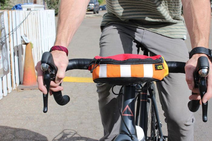 recycled hipster hip pack mounted on bike handlebars upcycled colorful versatile bikebag bikepacking